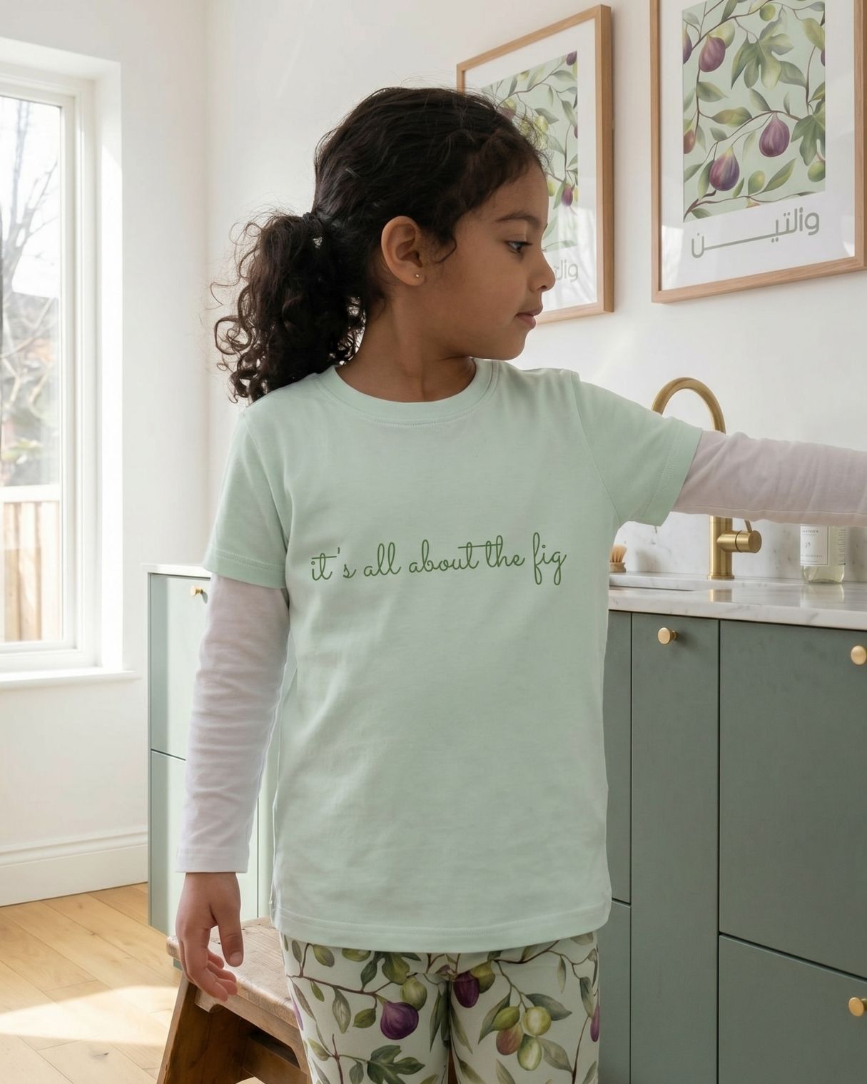 Child wearing it’s all about the fig kids t-shirt with olive and fig leggings at home