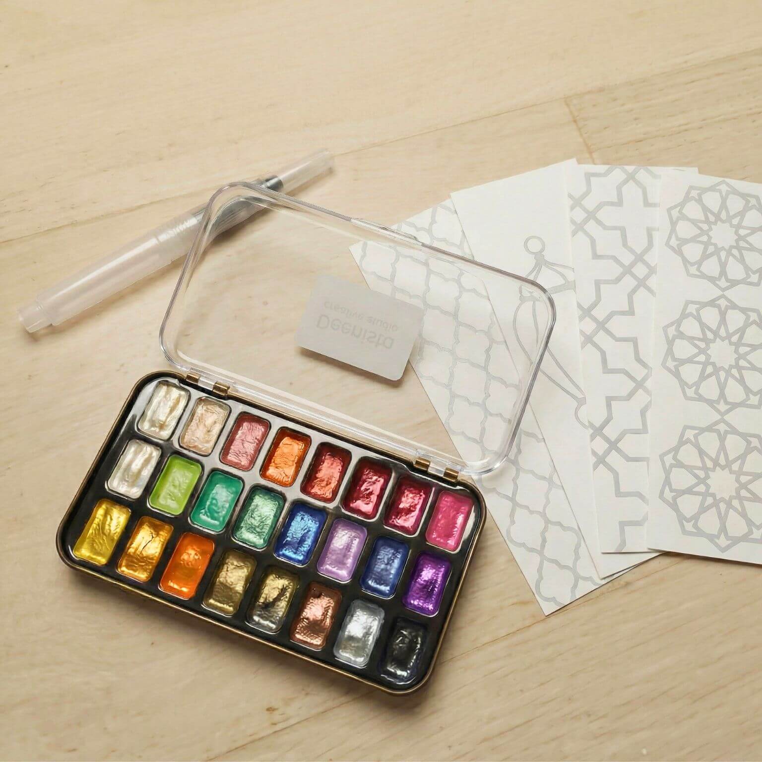 Open Islamic shimmer watercolor kit with 24 colours, refillable water brush, and four ready-to-paint Islamic bookmark cards
