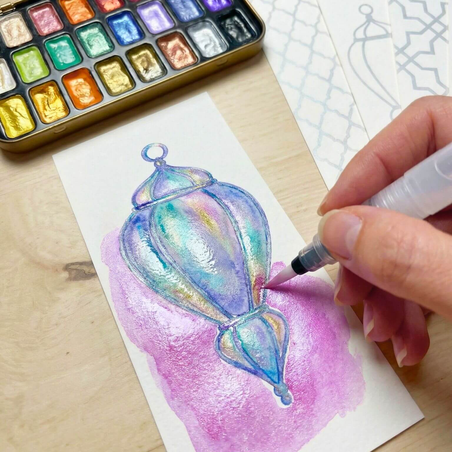 Hand painting an Islamic lantern bookmark with the Deenista Islamic shimmer watercolor kit using a refillable water brush